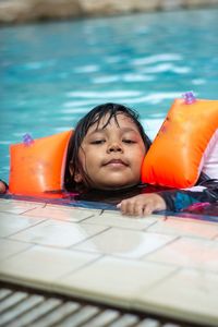 Portrait of young woman swimming in pool