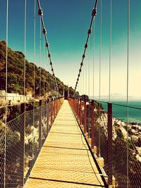 Long wooden jetty leading to calm blue sea