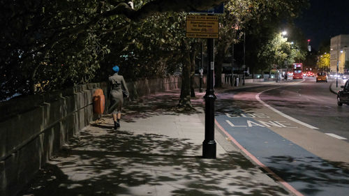 View of person walking on road in rain