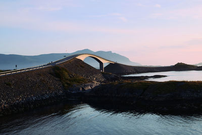 Bridge over river against sky during sunset