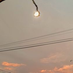 Low angle view of light bulb against sky at sunset