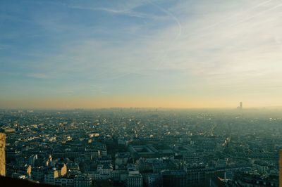 Aerial view of cityscape against cloudy sky