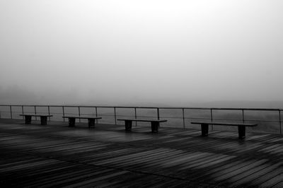 Empty wooden pier on sea against sky