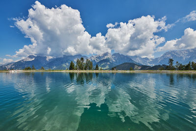 Scenic view of lake by mountains against sky