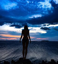 Rear view of silhouette woman walking on beach