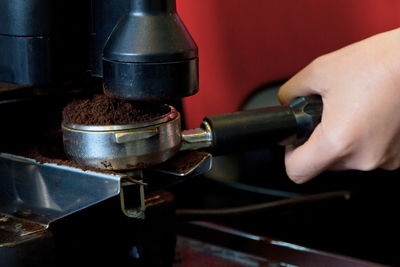 Cropped hand of person making coffee