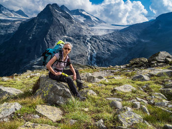 Portrait of mature female hiker sitting on mountain