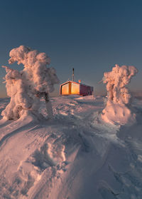 Snow covered buildings against sky