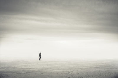 Man walking on beach at ebro delta during foggy weather