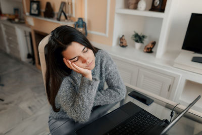 Young woman using mobile phone at home