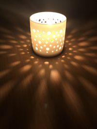 Close-up of illuminated lamp on table