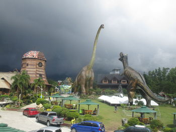 Statue of town against cloudy sky