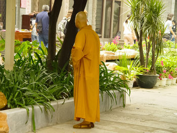 Rear view of man and woman standing by statue outside building