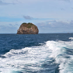 Rock formation in sea against sky