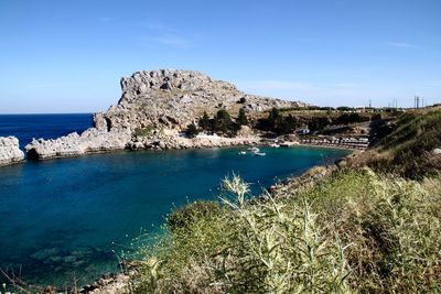 Scenic view of sea and mountains against blue sky