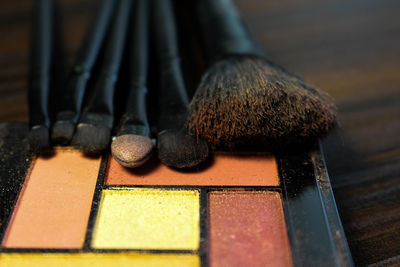 Close-up of face powder and make-up brushes on table