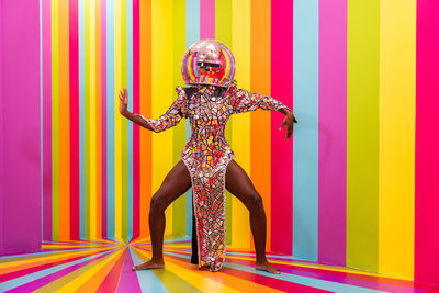 Full length of woman wearing costume against multi colored background