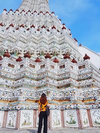 Full length of woman standing outside temple against building