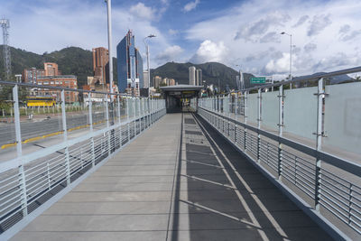 View of footbridge in city against sky