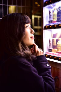 Side view of teenage girl looking away at store