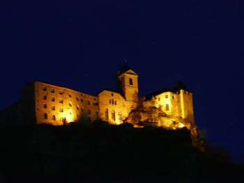 Low angle view of illuminated buildings against sky at night