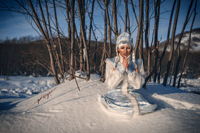 Portrait of young woman standing on snow