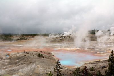 Smoke emitting from geyser against sky