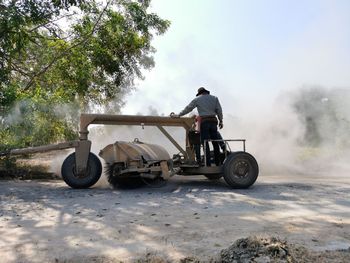 Rear view of man riding motorcycle on road