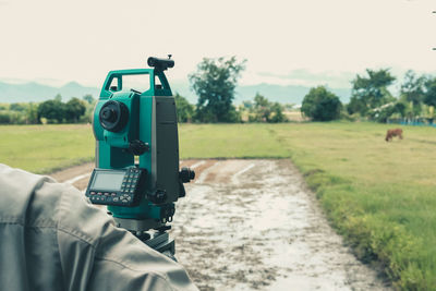 Man photographing on field against sky