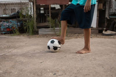 Low section of boy playing soccer ball