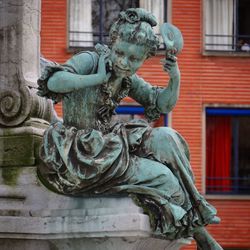 Low angle view of female statue against building
