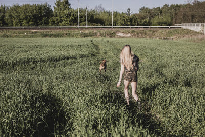 Rear view of woman walking on field