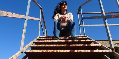 Low angle view of woman against clear sky