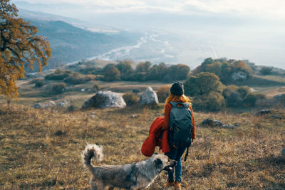 Rear view of man with horse in mountains