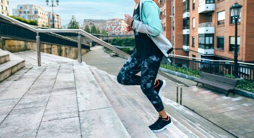 Woman training cardio running up stairs in town