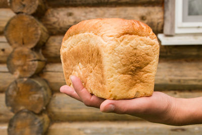 Cropped hands holding loaf of bread