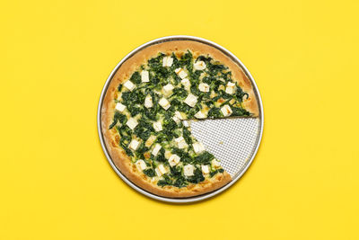 Top view, a vegetarian pizza with spinach, mozzarella, and feta. healthy pizza freshly backed.