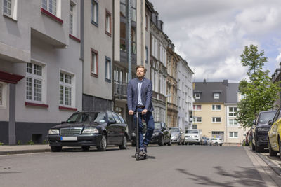 Businessman using e-scooter in the city