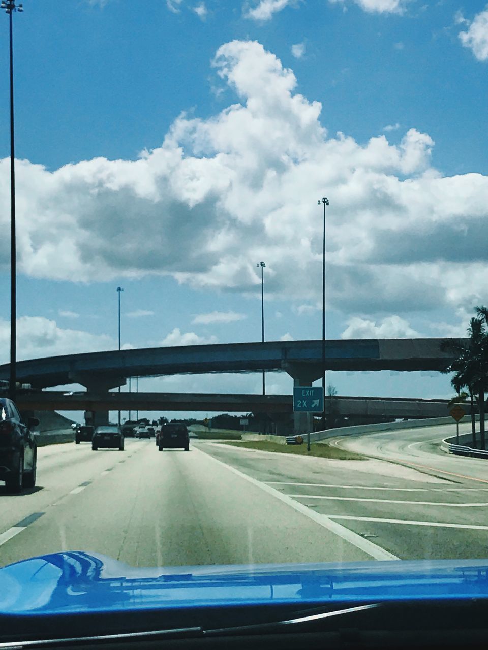 CARS ON ROAD AGAINST SKY SEEN FROM CAR WINDSHIELD