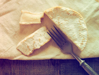 Close-up of cheese with fork on wooden table