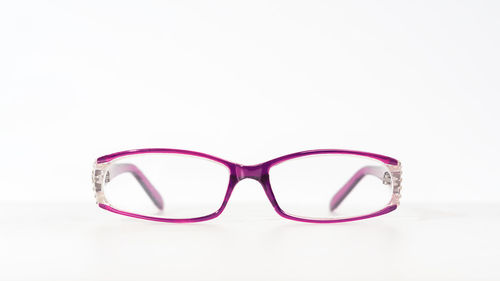 Close-up of eyeglasses on glass against white background