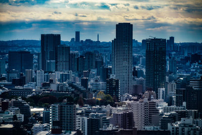 Modern buildings in city against sky during sunset