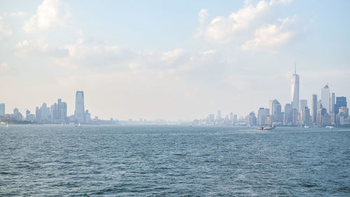 Hudson river and one world trade center against sky in city