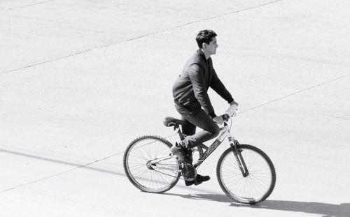 Side view of young man riding bicycle