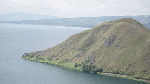 Scenic view of sea and mountains against sky