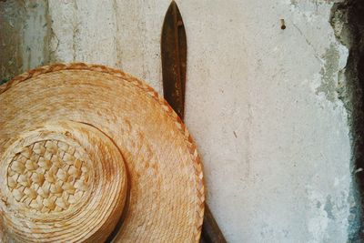 Close-up of straw hat and scissor hanging on wall