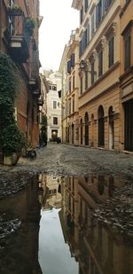 Reflection of buildings in puddle on street