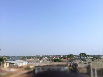 Houses in town against clear blue sky