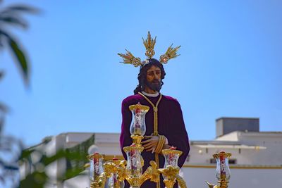 Low angle view of statue against building against sky