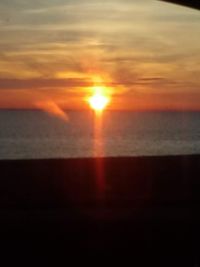 Scenic view of sea against orange sky